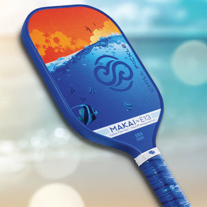 Chill Pickle Makai 13mm pickleball paddle angled lifestyle image with blurred beach background