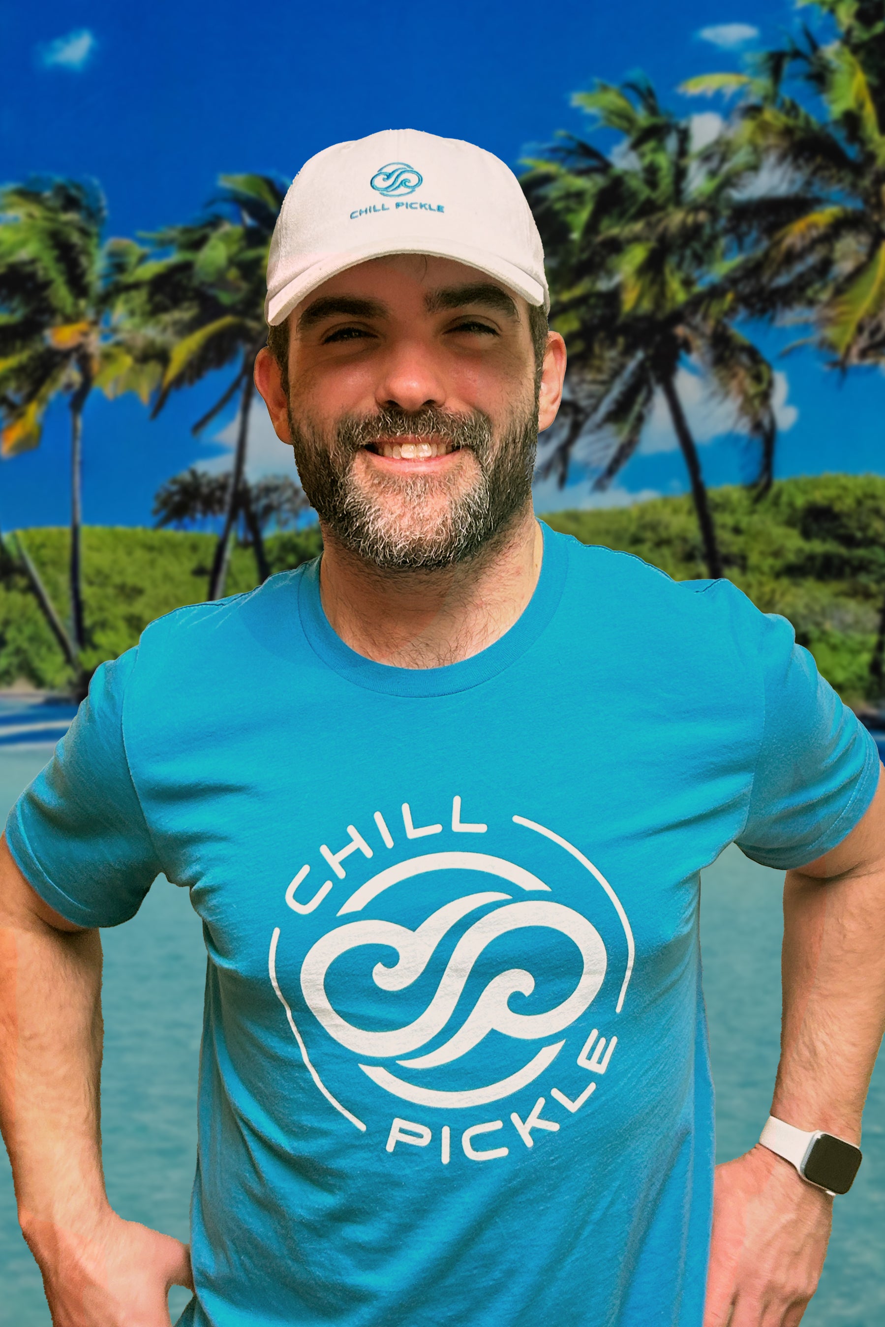 Man wearing a Chill Pickle logo t-shirt outdoors with palm trees in the background
