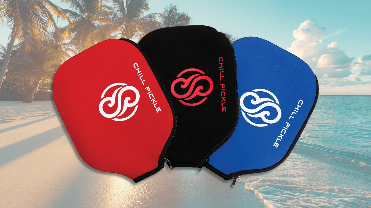 Three pickleball paddle covers in red, black, and blue with Chili Pickle branding against a beach background